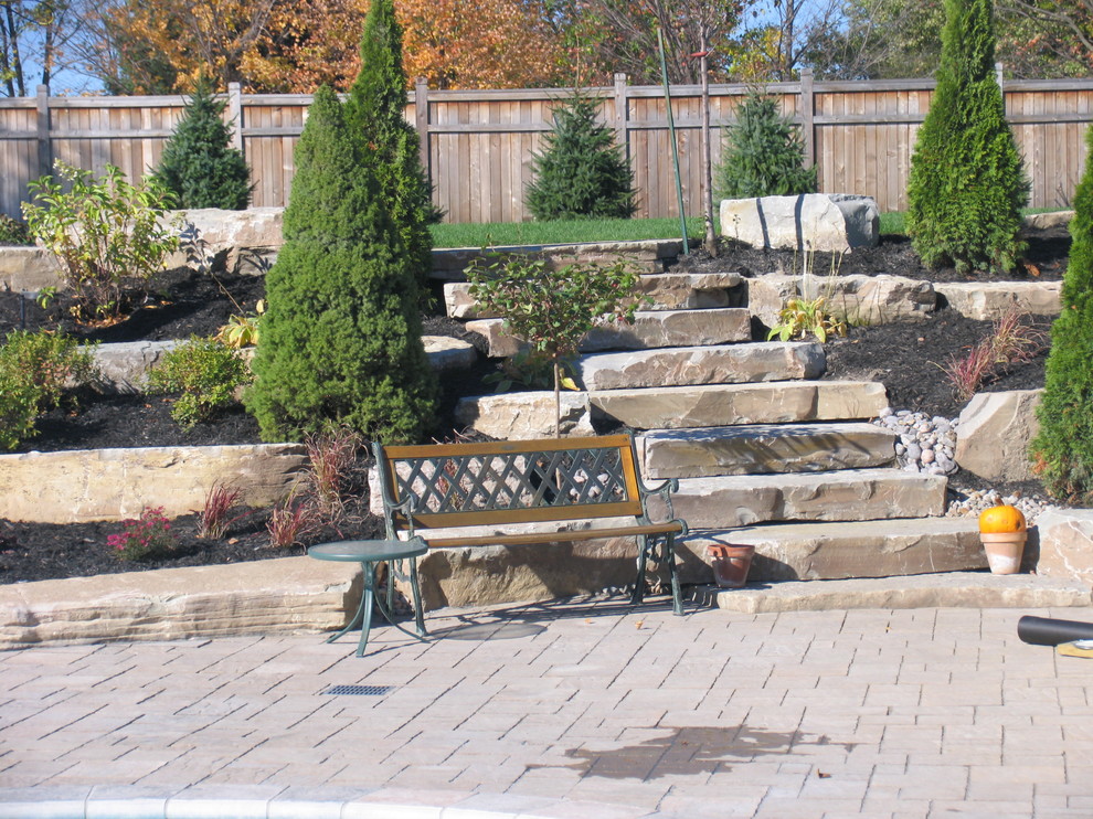 Inspiration for an arts and crafts front yard patio in Toronto with natural stone pavers and no cover.