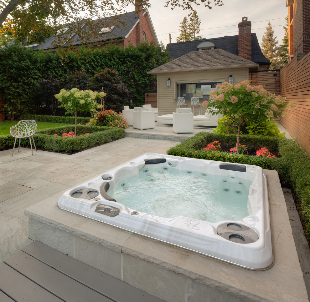 This is an example of a modern backyard pool in Toronto with a hot tub and tile.