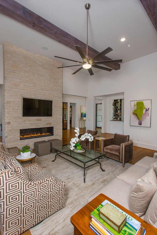 Photo of a large transitional open concept family room in Dallas with white walls, medium hardwood floors, a ribbon fireplace, a brick fireplace surround, a wall-mounted tv and brown floor.
