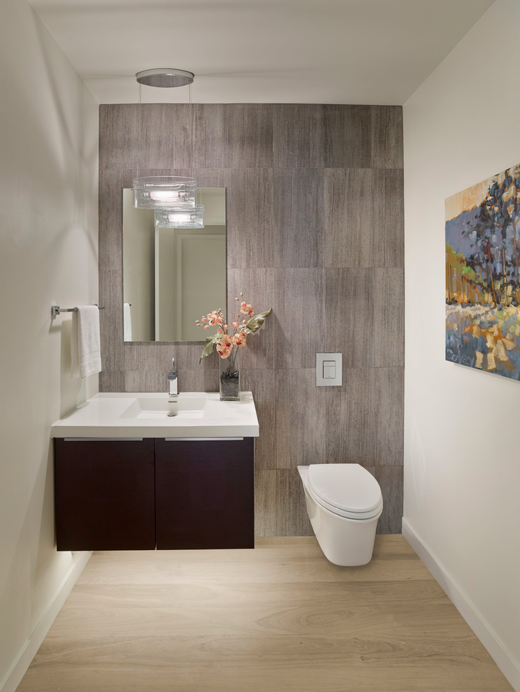 Contemporary bathroom in San Francisco with an integrated sink, flat-panel cabinets, dark wood cabinets, a wall-mount toilet, white walls and light hardwood floors.