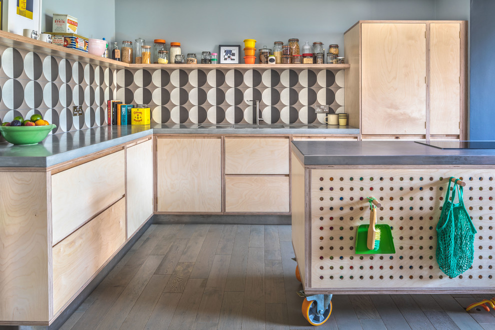 Photo of a mid-sized eclectic l-shaped eat-in kitchen in Other with a single-bowl sink, flat-panel cabinets, light wood cabinets, concrete benchtops, multi-coloured splashback, ceramic splashback, light hardwood floors, with island, grey floor and grey benchtop.