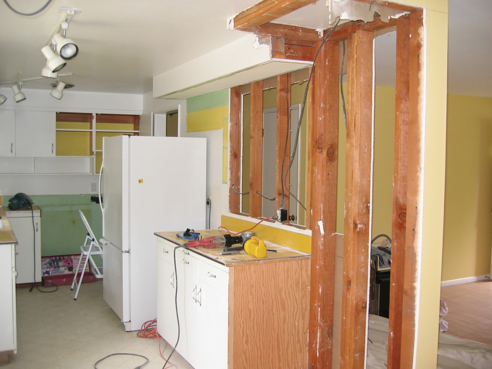 This is an example of a midcentury galley separate kitchen in Portland with a drop-in sink, flat-panel cabinets, beige cabinets, marble benchtops, beige splashback and white appliances.