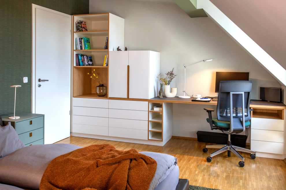 Photo of a medium sized contemporary study in Munich with green walls, light hardwood flooring and a built-in desk.