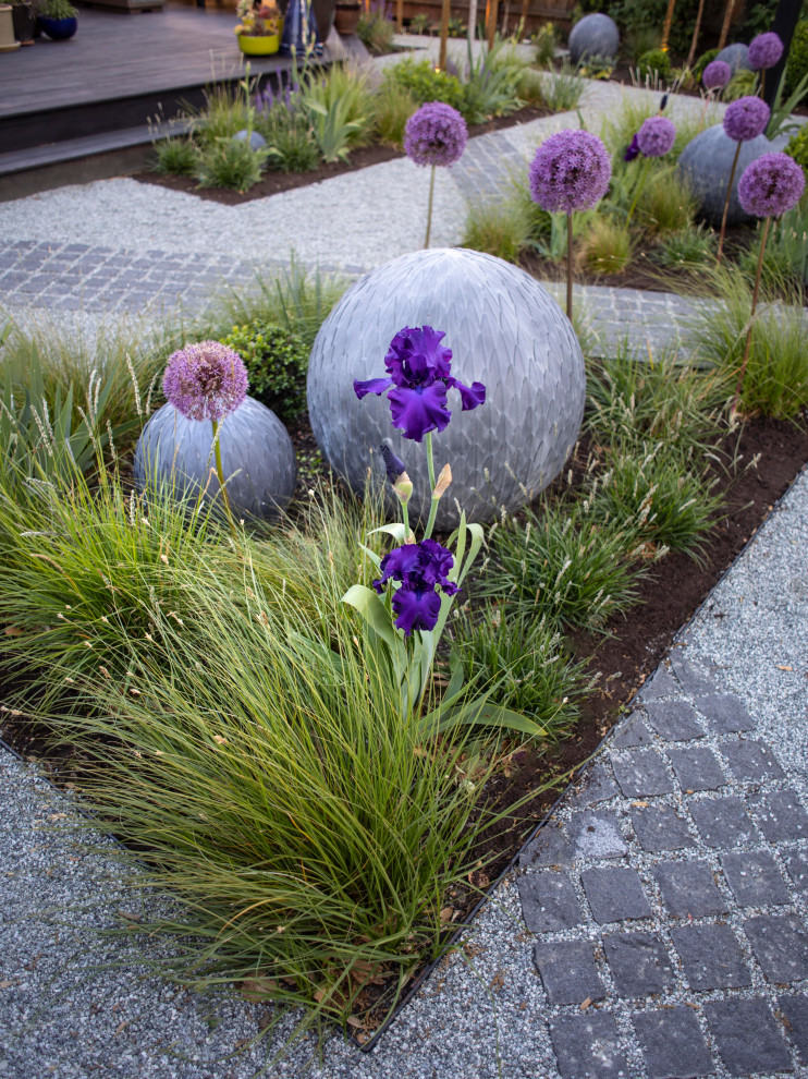 This is an example of a small contemporary partial sun backyard stone flower bed.