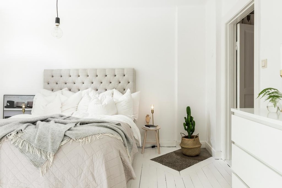 Large scandinavian master bedroom in Gothenburg with white walls, painted wood floors and no fireplace.