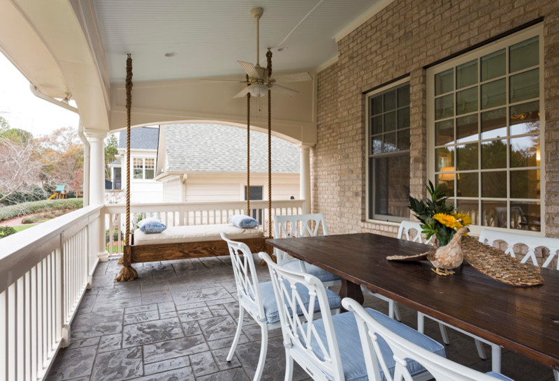 Design ideas for a large transitional backyard verandah in Charlotte with stamped concrete.