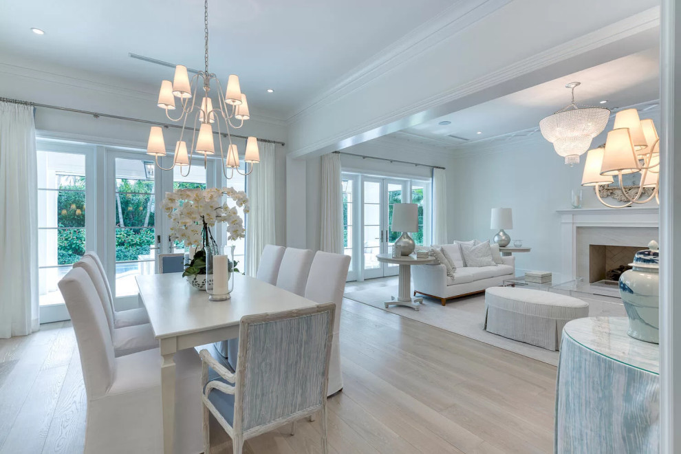 Inspiration for an expansive classic dining room in Miami with white walls, bamboo flooring, a standard fireplace, a stone fireplace surround, beige floors and wainscoting.