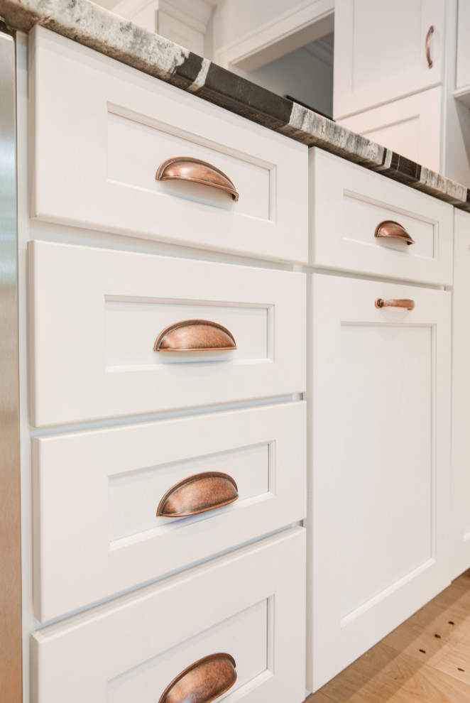 Bild på ett stort lantligt flerfärgad flerfärgat kök, med en rustik diskho, luckor med infälld panel, vita skåp, granitbänkskiva, rosa stänkskydd, stänkskydd i keramik, rostfria vitvaror, ljust trägolv, en halv köksö och beiget golv
