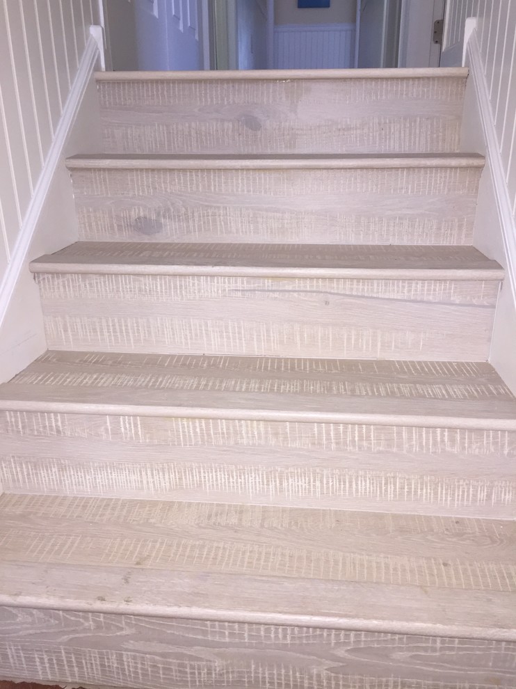 This is an example of a beach style wood straight staircase in Philadelphia with wood risers.