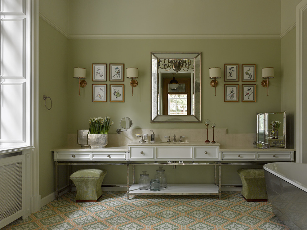 This is an example of a traditional master bathroom in Moscow with white cabinets, a freestanding tub, green walls, an undermount sink, multi-coloured floor, beige benchtops and recessed-panel cabinets.