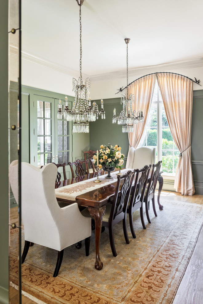 Ispirazione per una grande sala da pranzo classica chiusa con pareti verdi, parquet chiaro, pavimento marrone e boiserie