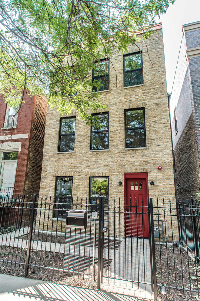 Photo of a mid-sized transitional three-storey brick beige house exterior in Chicago with a flat roof.