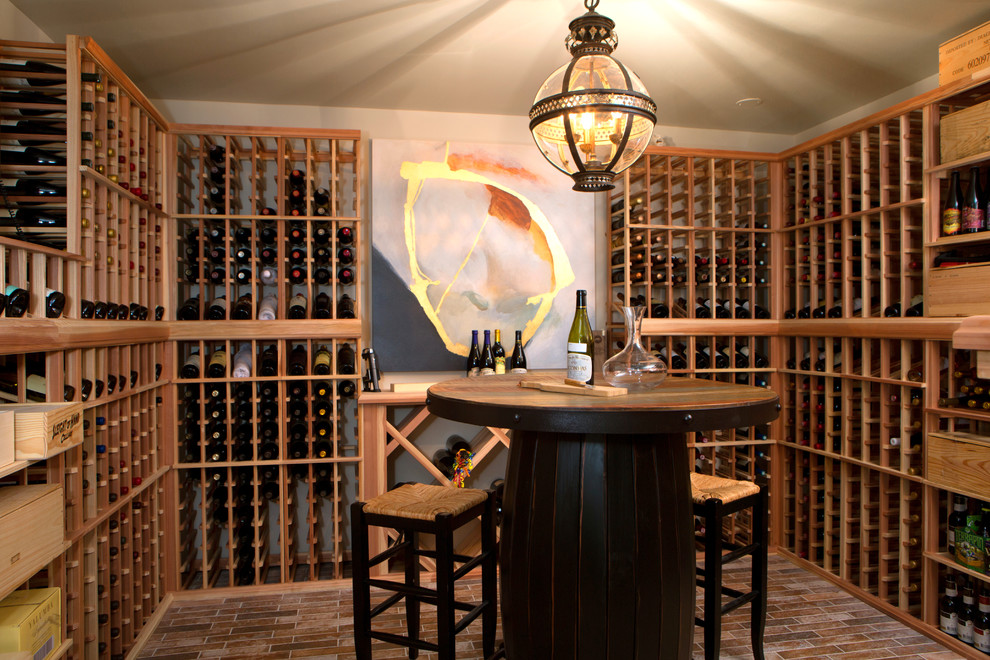 This is an example of a small eclectic wine cellar in Nashville with brick floors, storage racks and brown floor.