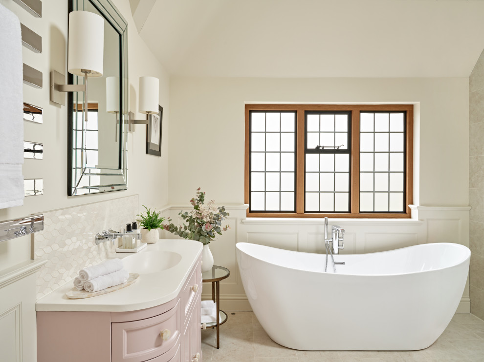 Idéer för ett klassiskt vit en-suite badrum, med luckor med infälld panel, ett fristående badkar, vit kakel, vita väggar, ett integrerad handfat, bänkskiva i kvarts och beiget golv