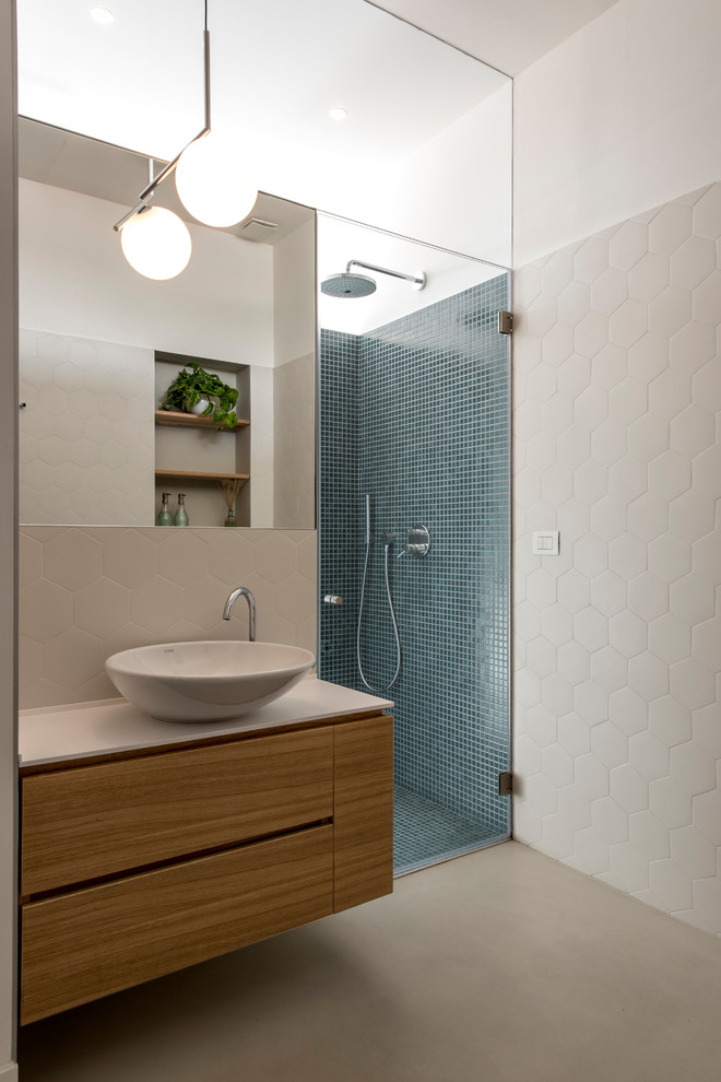 This is an example of a small modern bathroom in Milan with flat-panel cabinets, brown cabinets, multi-coloured tile, multi-coloured walls, a vessel sink, solid surface benchtops and grey floor.