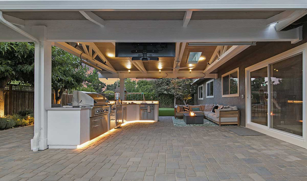 Стильный дизайн: большой двор на заднем дворе в стиле неоклассика (современная классика) с летней кухней, мощением тротуарной плиткой и навесом - последний тренд