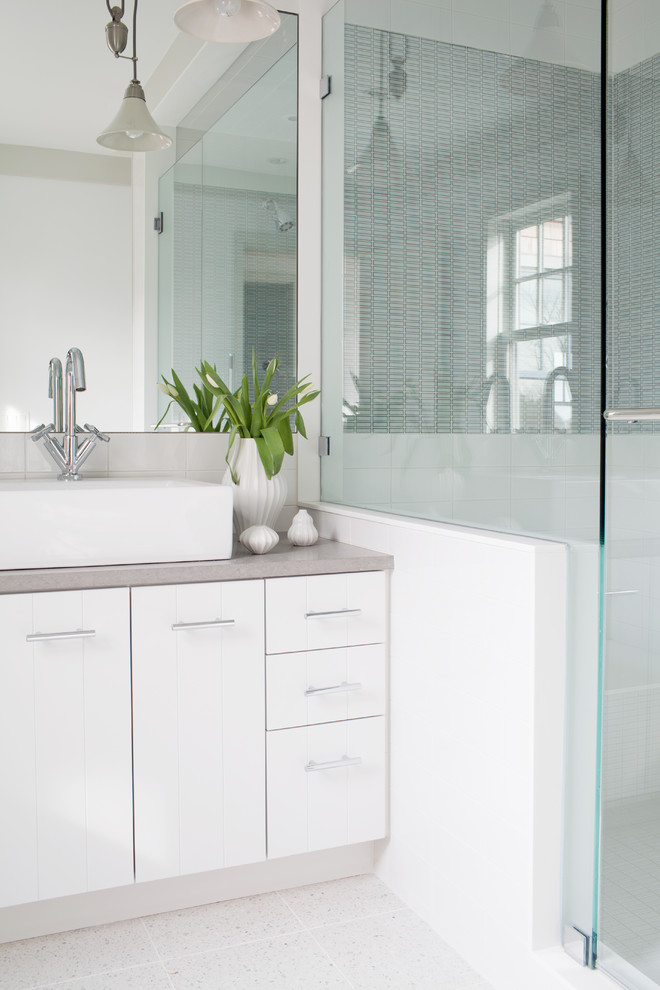 This is an example of a contemporary master bathroom in Boston with flat-panel cabinets, white cabinets, an open shower, mirror tile, white walls, a vessel sink, white floor, an open shower and grey benchtops.