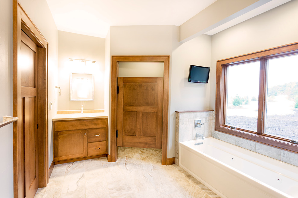 Inspiration for a large arts and crafts master bathroom in Other with shaker cabinets, medium wood cabinets, an alcove tub, a corner shower, a two-piece toilet, multi-coloured tile, stone tile, beige walls, marble floors, an undermount sink and laminate benchtops.