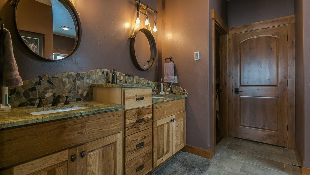 This is an example of a large country master bathroom in Seattle with flat-panel cabinets, medium wood cabinets, an alcove shower, a two-piece toilet, brown walls, porcelain floors, an undermount sink, marble benchtops, grey floor, a hinged shower door and green benchtops.