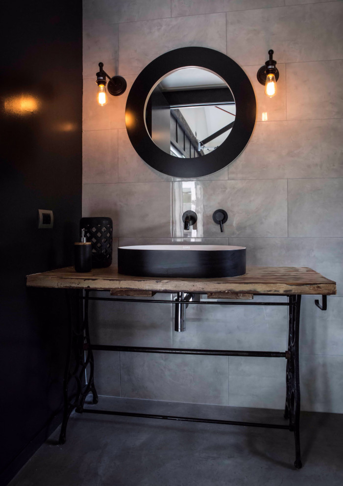 Small industrial 3/4 bathroom in Auckland with medium wood cabinets, an open shower, a wall-mount toilet, gray tile, ceramic tile, grey walls, concrete floors, a vessel sink, wood benchtops, grey floor, an open shower, a single vanity, a freestanding vanity, timber and wood walls.