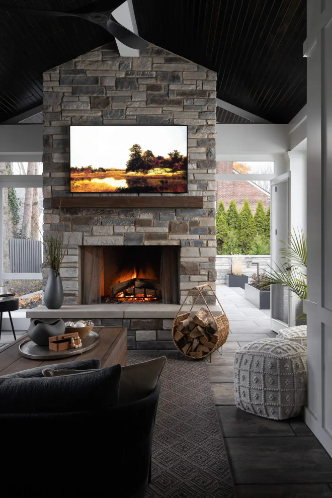 Large transitional concrete floor and gray floor porch idea in Detroit with a standard fireplace and a stone fireplace