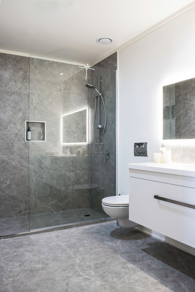 Design ideas for a mid-sized contemporary master bathroom in Other with white cabinets, a double shower, gray tile, ceramic floors, engineered quartz benchtops, grey floor, a sliding shower screen and white benchtops.