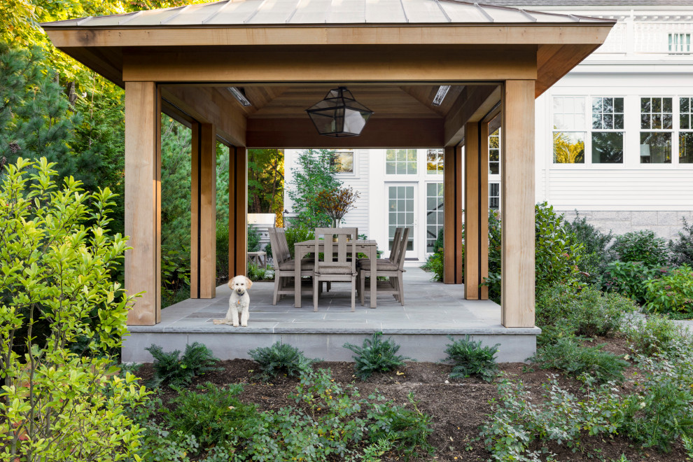 Esempio di un patio o portico tradizionale di medie dimensioni e dietro casa con un focolare, pavimentazioni in pietra naturale e una pergola