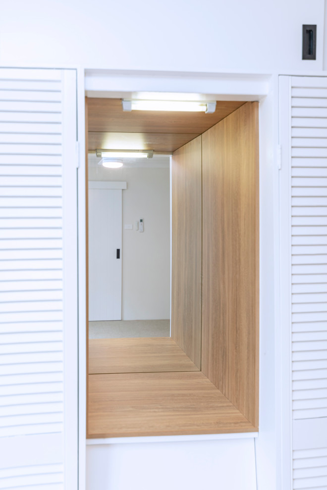 This is an example of a small midcentury master bedroom in Central Coast with white walls, carpet and beige floor.