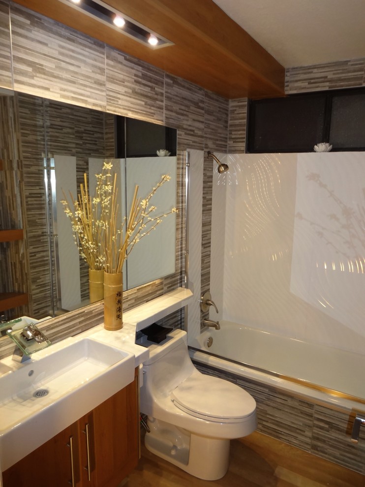 Mid-sized asian kids bathroom in Orange County with raised-panel cabinets, beige cabinets, an alcove tub, a shower/bathtub combo, a one-piece toilet, white tile, ceramic tile, beige walls, vinyl floors, a trough sink, tile benchtops, beige floor, a sliding shower screen, white benchtops, a niche, a single vanity and a floating vanity.
