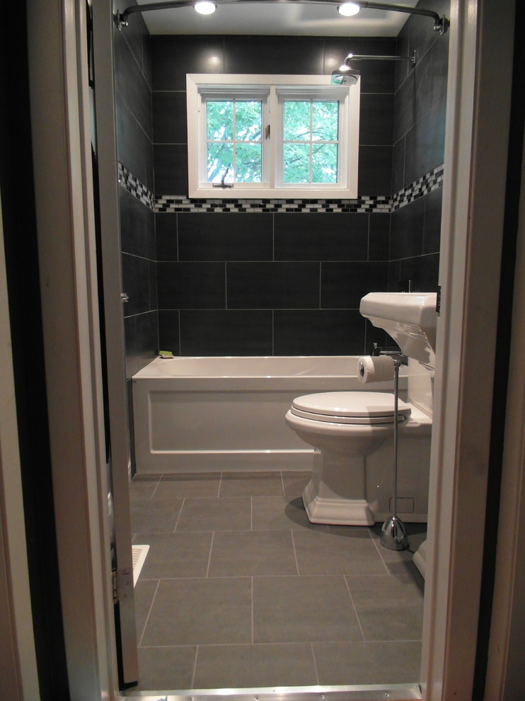 Photo of a small contemporary 3/4 bathroom in Ottawa with an alcove tub, a shower/bathtub combo, a two-piece toilet, black tile, gray tile, multi-coloured tile, matchstick tile, black walls, porcelain floors, a pedestal sink, grey floor and a shower curtain.