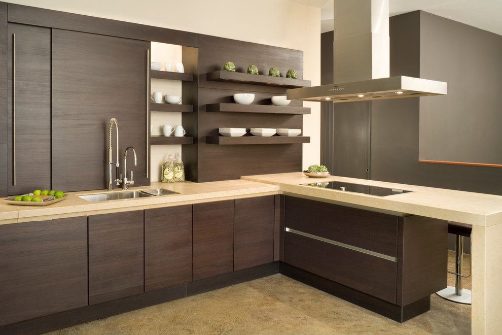 This is an example of a mid-sized contemporary l-shaped eat-in kitchen in Kansas City with an undermount sink, flat-panel cabinets, brown cabinets, limestone benchtops, brown splashback, panelled appliances, concrete floors and a peninsula.