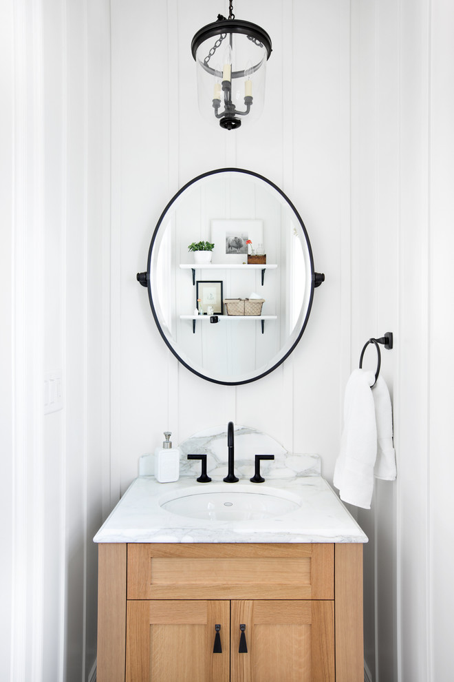 Inspiration for a small beach style powder room in Vancouver with an undermount sink, shaker cabinets, light wood cabinets and white walls.