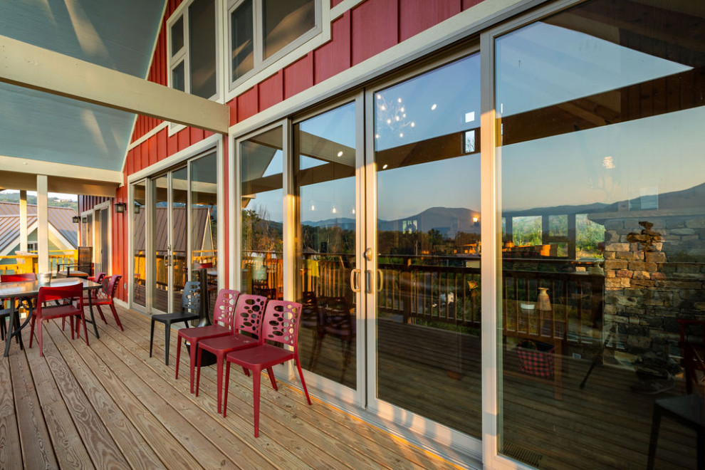 Mid-sized mountain style backyard deck photo with a roof extension