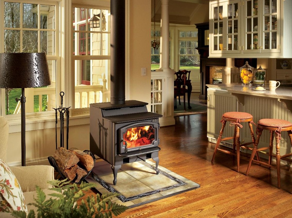 Country living room in Seattle with beige walls, medium hardwood floors, a standard fireplace and brown floor.