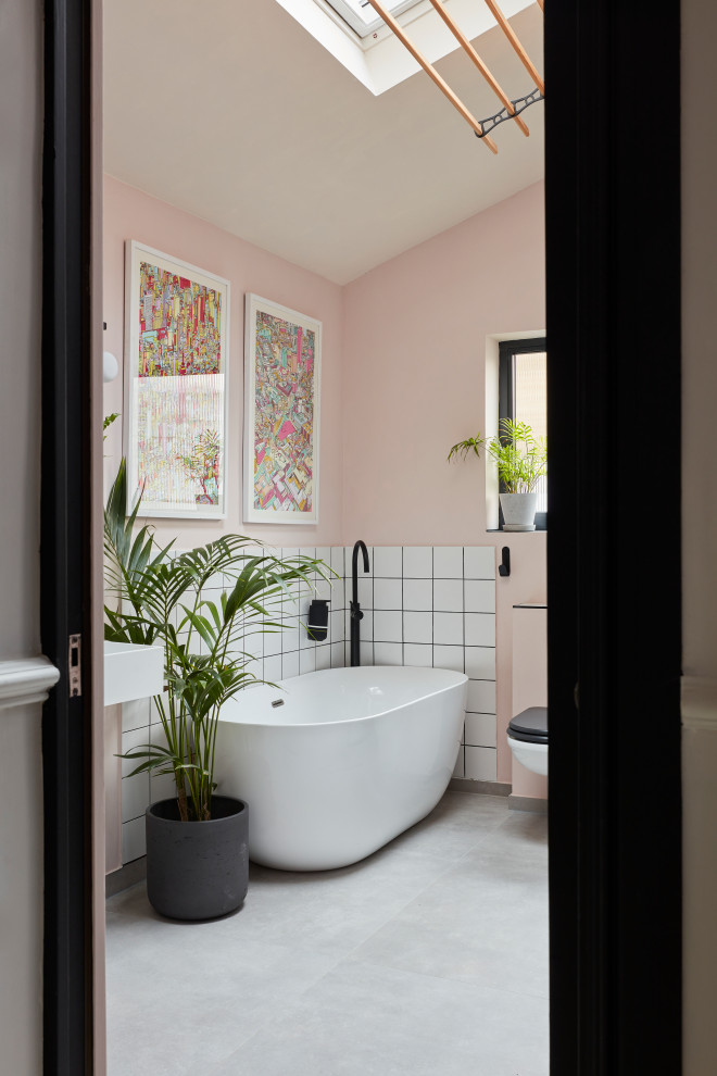 Inspiration pour une salle de bain bohème de taille moyenne pour enfant avec une baignoire indépendante, une douche ouverte, WC suspendus, un carrelage noir et blanc, un mur rose, sol en béton ciré, un lavabo suspendu, un sol gris, aucune cabine et meuble simple vasque.