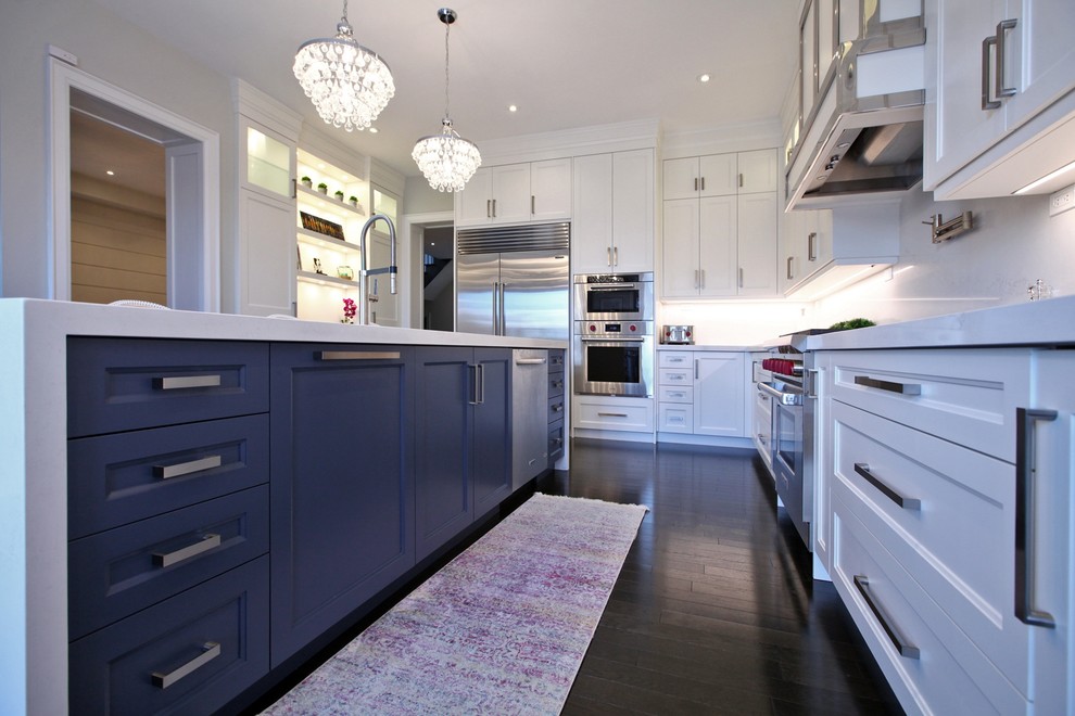 Photo of a large beach style l-shaped separate kitchen in Toronto with an undermount sink, shaker cabinets, white cabinets, marble benchtops, stainless steel appliances, dark hardwood floors, with island, brown floor and white benchtop.