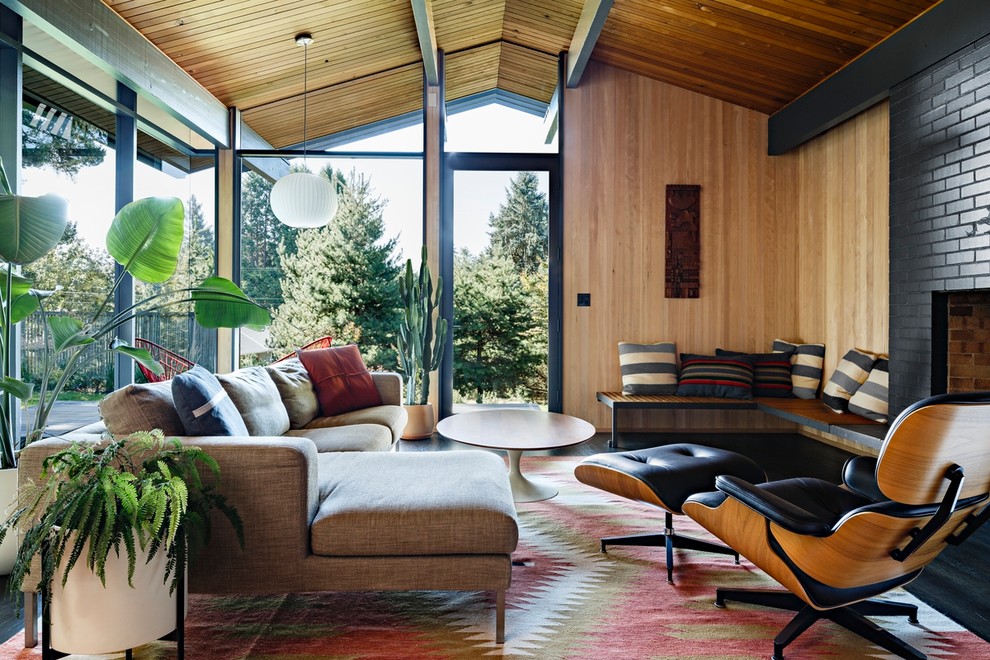 Midcentury open concept living room in Portland with beige walls, dark hardwood floors, a standard fireplace, a brick fireplace surround and brown floor.