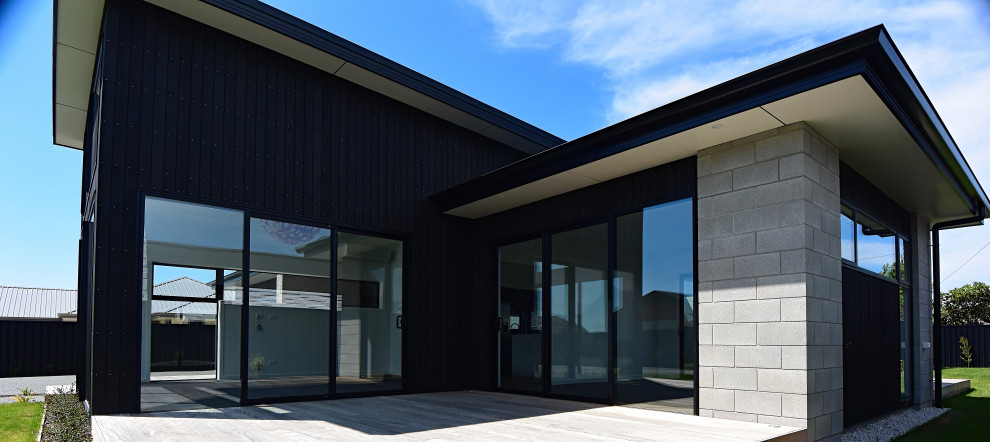 Idee per la facciata di una casa nera moderna con rivestimento in cemento e tetto nero