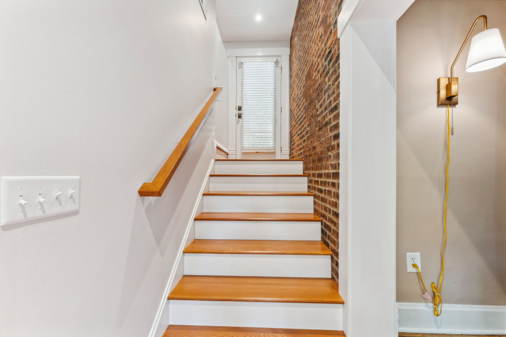 Medium sized classic wood l-shaped wood railing staircase in Columbus with painted wood risers and brick walls.