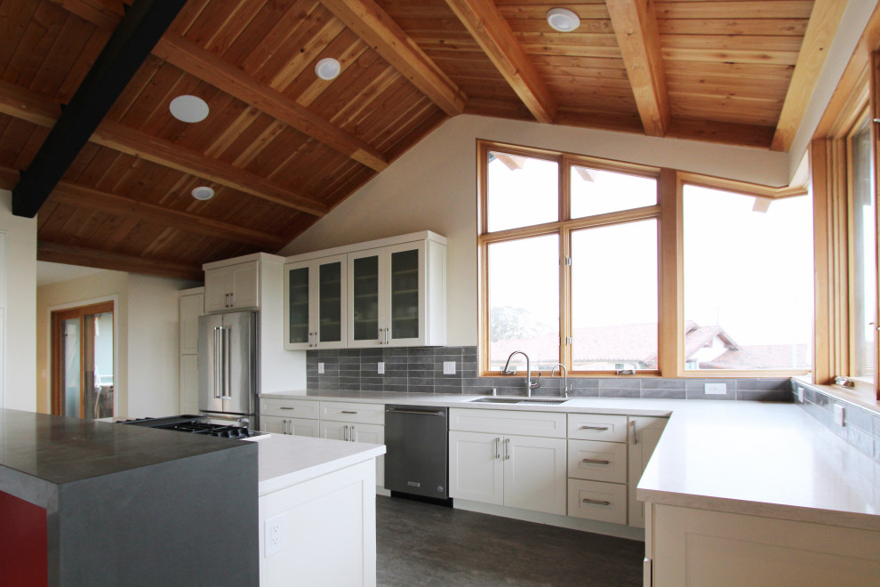 Open concept kitchen - mid-sized transitional l-shaped gray floor open concept kitchen idea with an undermount sink, shaker cabinets, white cabinets, quartz countertops, gray backsplash, ceramic backsplash, stainless steel appliances, an island and multicolored countertops