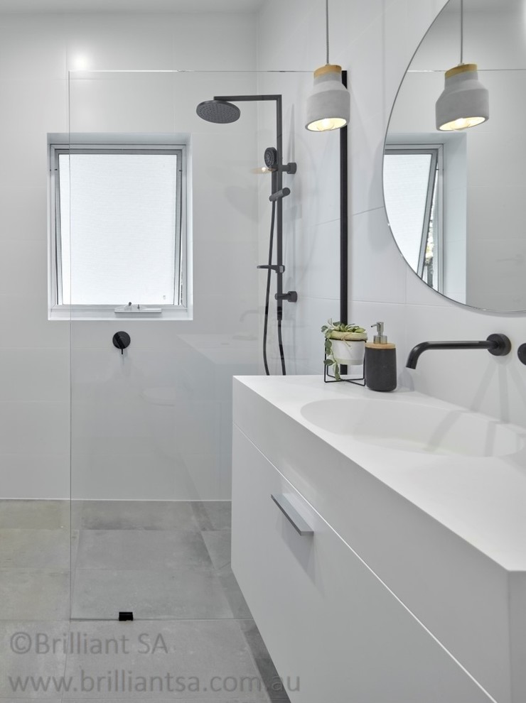 Mid-sized contemporary 3/4 bathroom in Adelaide with white cabinets, an open shower, a one-piece toilet, white walls, porcelain floors, a drop-in sink, grey floor, an open shower, flat-panel cabinets, white tile, ceramic tile, quartzite benchtops and white benchtops.