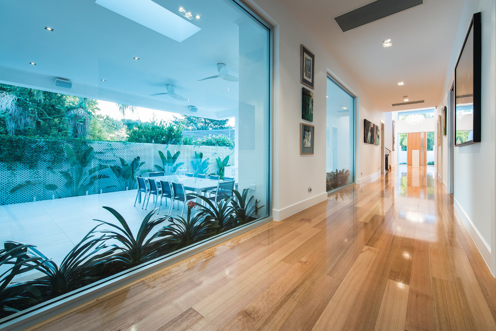 Design ideas for a large contemporary hallway in Adelaide with white walls and light hardwood floors.