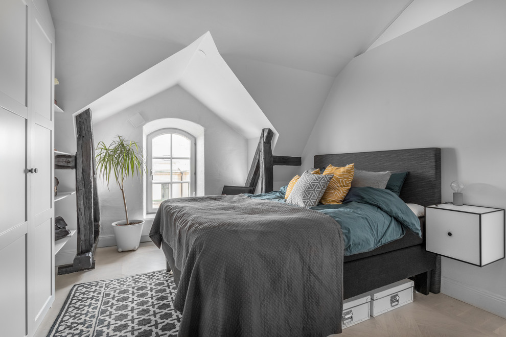 Design ideas for a mid-sized scandinavian master bedroom in Stockholm with white walls, light hardwood floors, no fireplace and beige floor.
