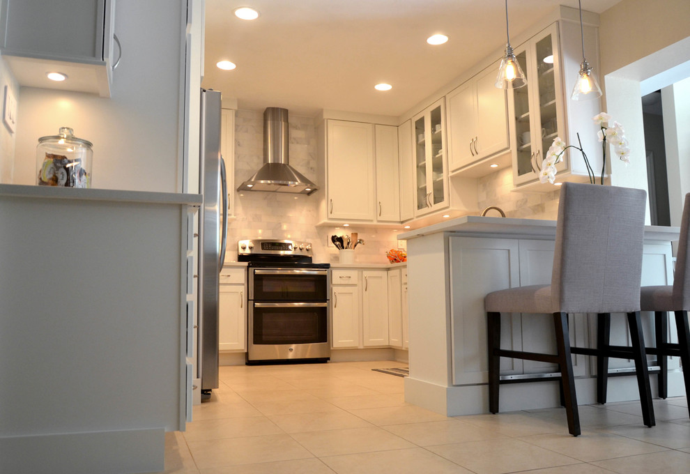 Small transitional u-shaped kitchen photo in Miami with an undermount sink, shaker cabinets, white cabinets, quartz countertops, gray backsplash and stainless steel appliances