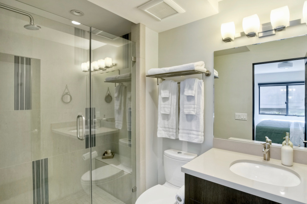 Photo of a large beach style bathroom in San Diego with flat-panel cabinets, brown cabinets, porcelain floors, grey floor and vaulted.