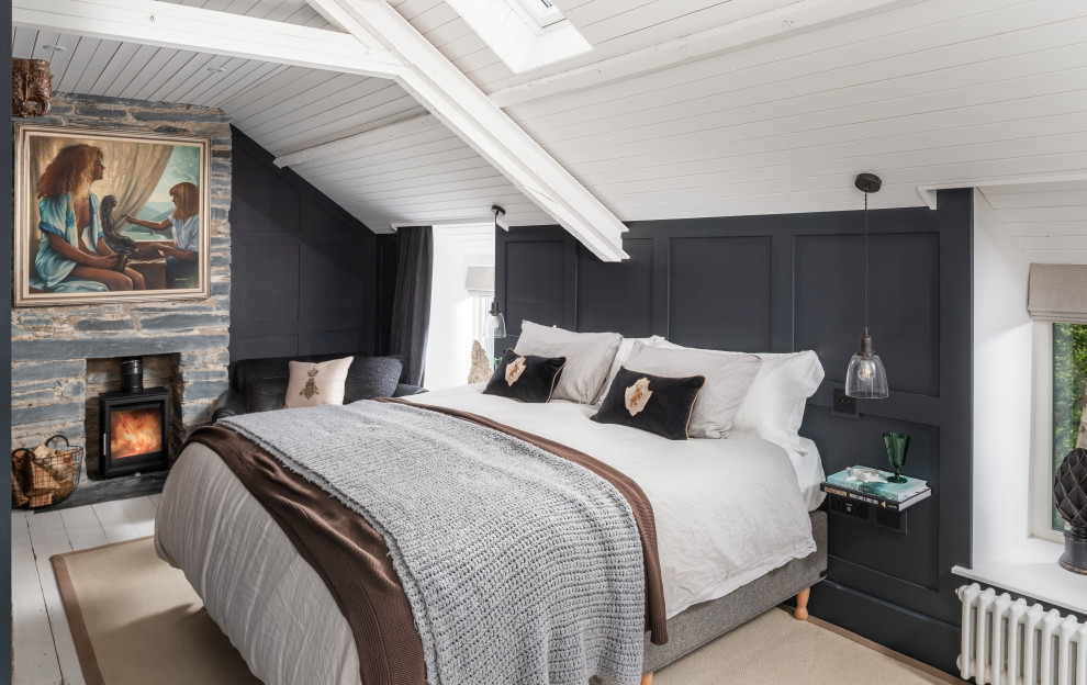 This is an example of a mid-sized country master bedroom in Other with grey walls, painted wood floors, a wood stove, a brick fireplace surround, white floor, vaulted and panelled walls.