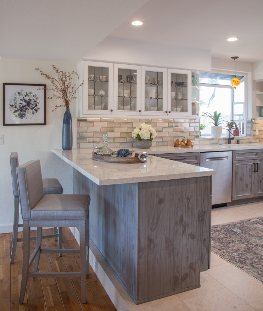 Inspiration for a mid-sized transitional u-shaped eat-in kitchen in San Diego with an undermount sink, shaker cabinets, distressed cabinets, quartz benchtops, blue splashback, ceramic splashback, stainless steel appliances, travertine floors, a peninsula, beige floor and white benchtop.