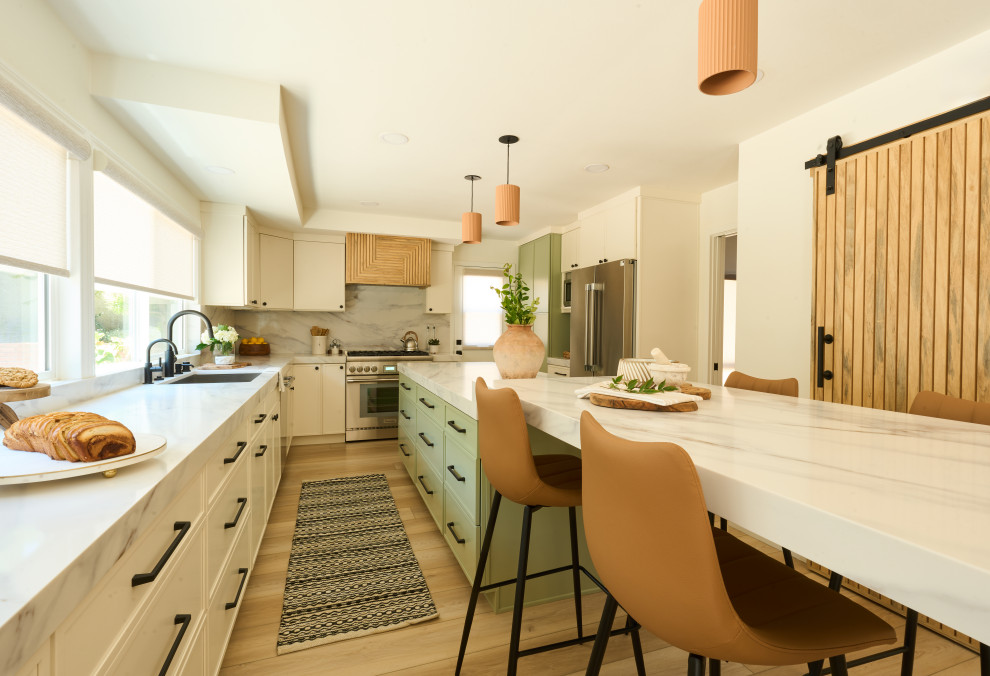 Large transitional u-shaped vinyl floor and brown floor eat-in kitchen photo in Orange County with an undermount sink, shaker cabinets, green cabinets, quartz countertops, white backsplash, quartz backsplash, stainless steel appliances, two islands and white countertops