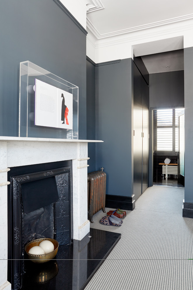 This is an example of a large contemporary master bedroom in London with grey walls, carpet, a standard fireplace and a stone fireplace surround.