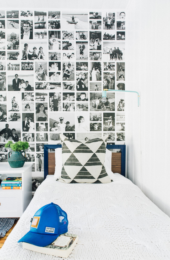 Photo of a beach style gender-neutral kids' bedroom in Charleston with white walls, medium hardwood floors and brown floor.